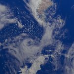 Vista da Terra a partir do espaço, com oceanos e extensas formações de nuvens na atmosfera.