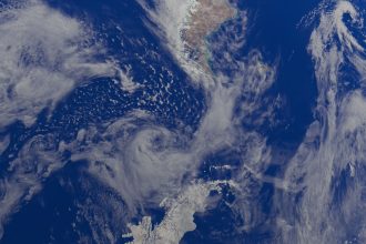 Vista da Terra a partir do espaço, com oceanos e extensas formações de nuvens na atmosfera.