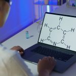 Cientista analisa uma fórmula química em um laptop em um laboratório