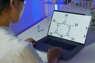 Cientista analisa uma fórmula química em um laptop em um laboratório