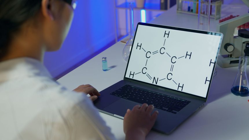 Cientista analisa uma fórmula química em um laptop em um laboratório