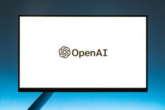 Logo da OpenAI exibido em um monitor diante de um fundo azul em degradê