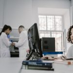 Pesquisadora trabalha em um computador em um laboratório acadêmico de computação.