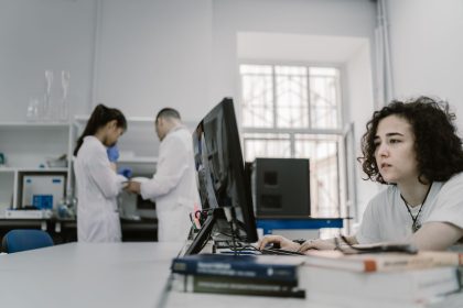 Pesquisadora trabalha em um computador em um laboratório acadêmico de computação.