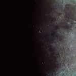 Detalhe da superfície da Lua, com crateras e texturas lunares visíveis.