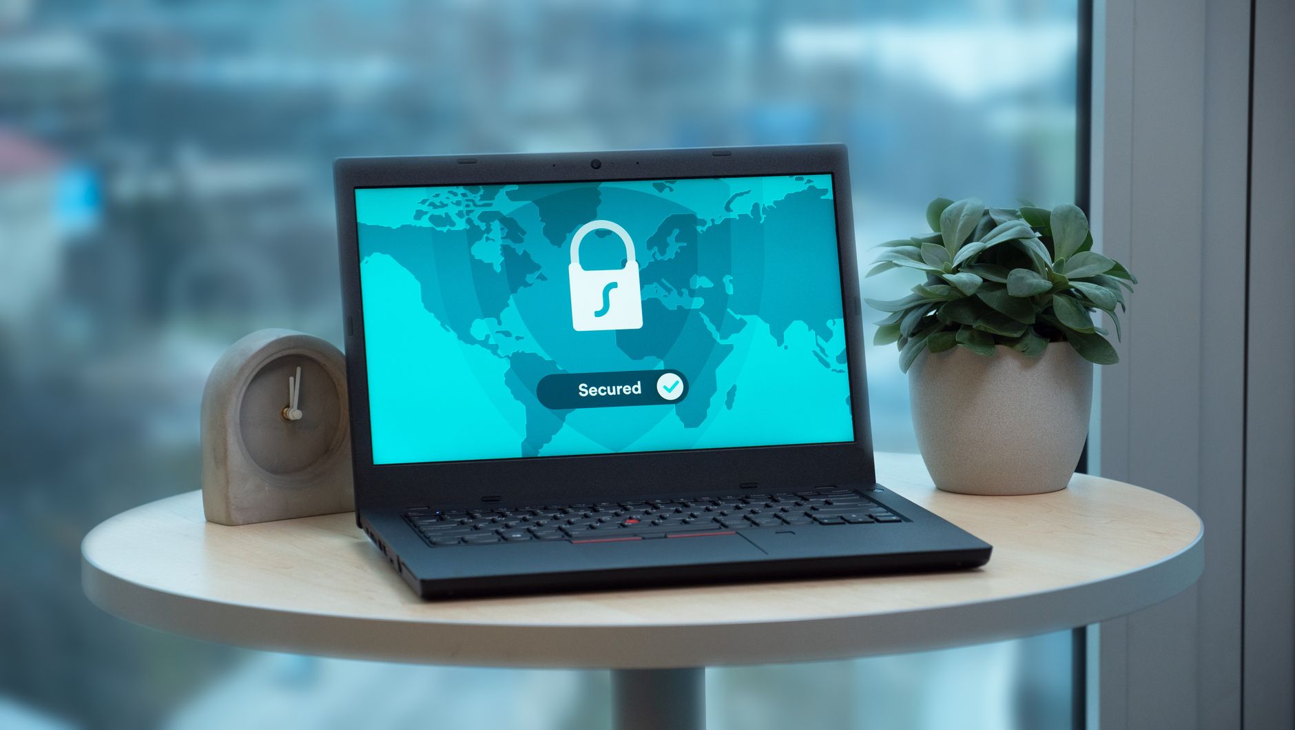 Laptop exibindo um ícone de cadeado sobre uma mesa, em uma composição que remete à segurança e à proteção de dados digitais.