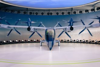 Protótipo futurista de aeronave elétrica com hélices exposto em ambiente interno.