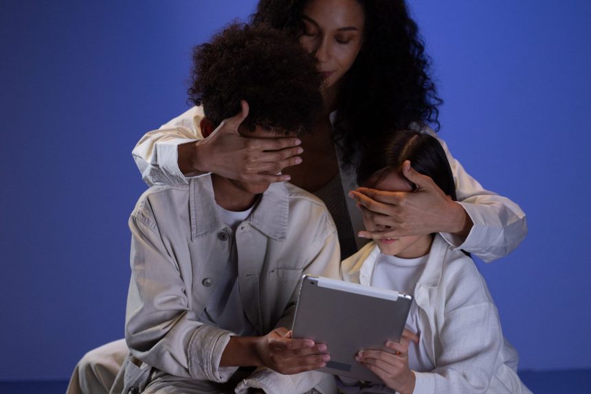 Mãe cobre os olhos de duas crianças enquanto elas seguram um tablet, simbolizando o controle parental na internet.