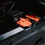 Bateria de carro elétrico instalada no compartimento do motor, representando o uso industrial de minerais críticos em tecnologias de baixo carbono