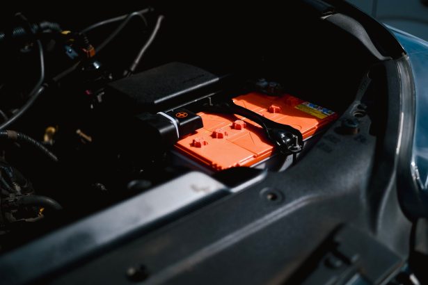 Bateria de carro elétrico instalada no compartimento do motor, representando o uso industrial de minerais críticos em tecnologias de baixo carbono